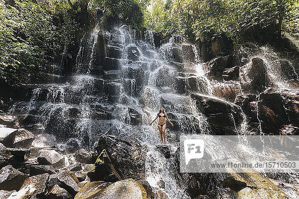 Junge Frau in der Nähe des Kanto-Lampo-Wasserfalls  Bali  Indonesien