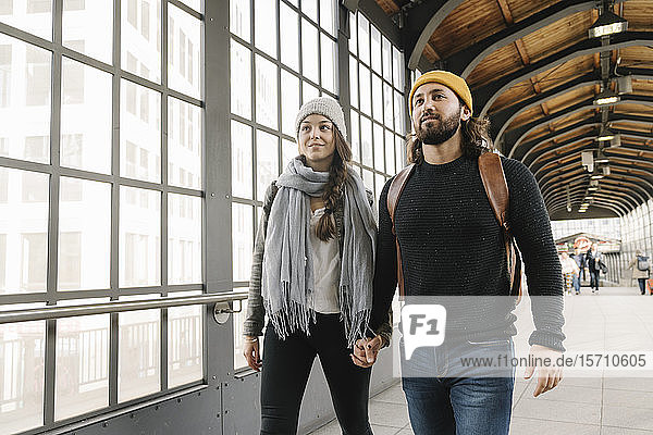 Junges Paar geht Hand in Hand an einer U-Bahn-Station  Berlin  Deutschland