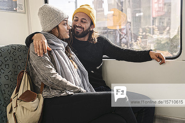 Glückliches junges Paar sitzt in der U-Bahn