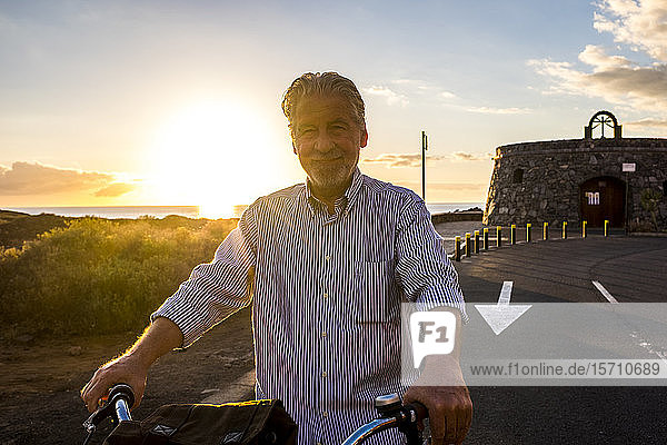 Älterer Mann auf dem Fahrrad bei Sonnenuntergang  Teneriffa