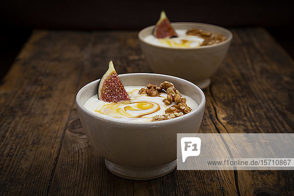 Schalen mit griechischem Joghurt mit Honig Walnüssen und Feigen