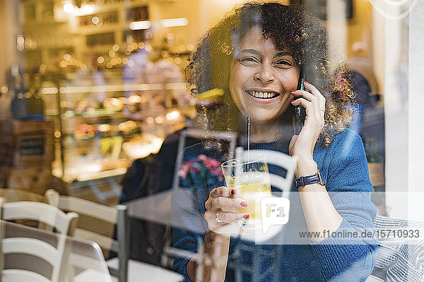 Portrait of happy woman on the phone in a cafe