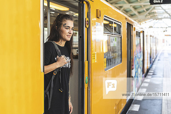 Porträt einer tätowierten jungen Frau  die aus einer Hochbahn aussteigt  Berlin  Deutschland