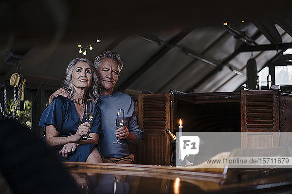 Porträt eines älteren Ehepaares bei einem Candlelight-Dinner auf einem Boot im Bootshaus
