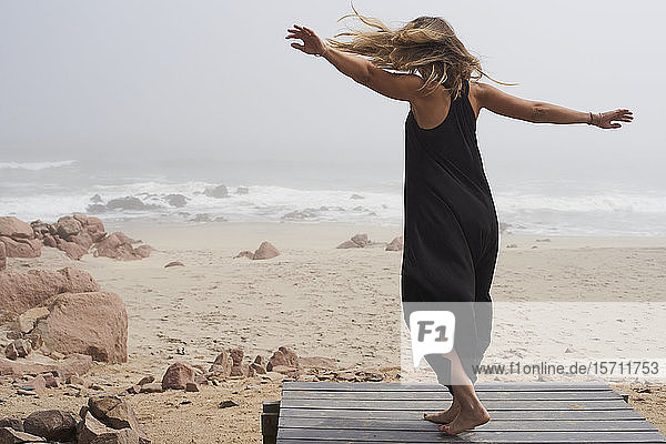 Rückansicht einer am Meer tanzenden Frau  Cape Cross  Namibia