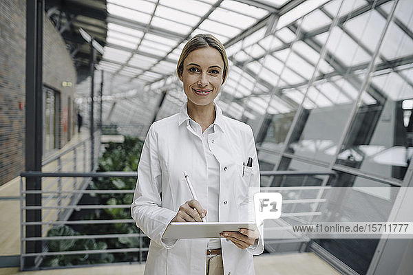 Porträt einer selbstbewussten Ärztin  die eine Tablette benutzt