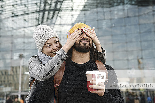 Glückliche junge Frau überrascht ihren Freund am Hauptbahnhof  Berlin  Deutschland