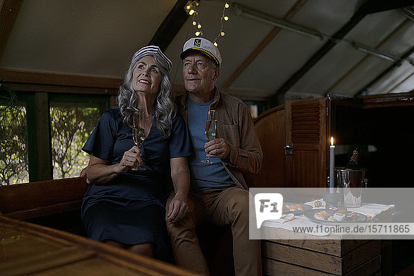Senior couple having a candlelight dinner on a boat in boathouse
