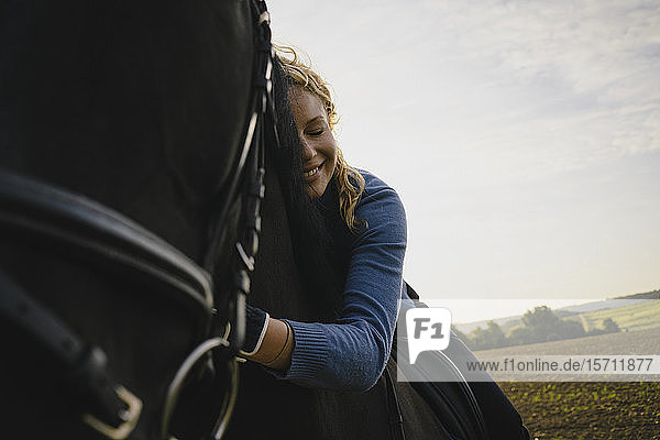 Affectionate woman on horse on a field in the countryside