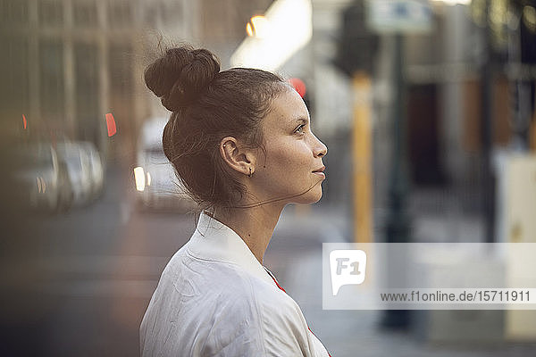 Profile view of confident young woman in the city