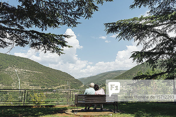 Back view of senior couple sitting on a bench looking at view  Jaca  Spain