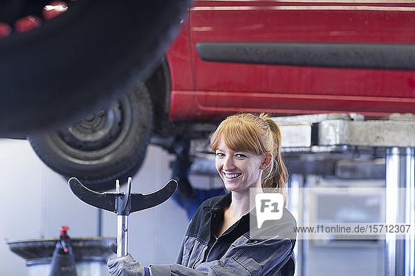 Smiling female car mechanic in repair garage