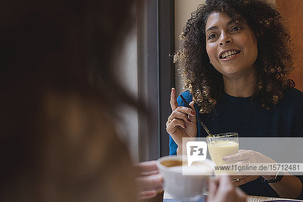 Two women meeting and talking in a cafe