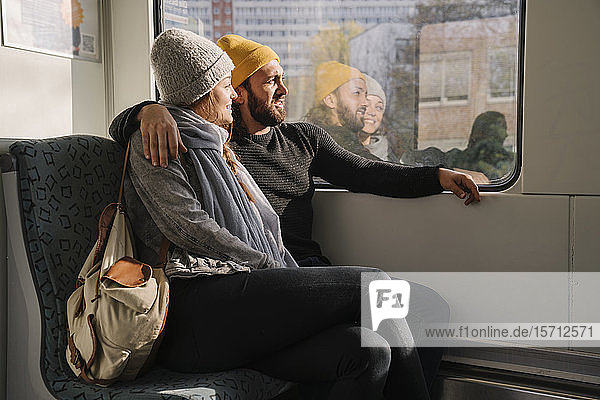 Young couple in a subway looking out of window