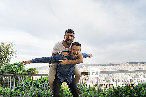 Porträt eines glücklichen schwulen Paares  das sich auf der Aussichtsterrasse amüsiert  Barcelona  Spanien