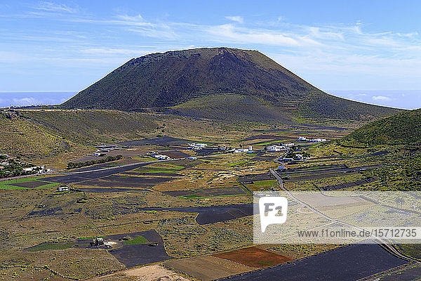 Spain Canary Islands Guinate Fields in front of rural village with Monte Corona volcano looming in background
