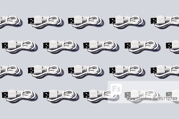 3D-Illustration  weiße USB-Kabel in einer Reihe auf grauem Hintergrund