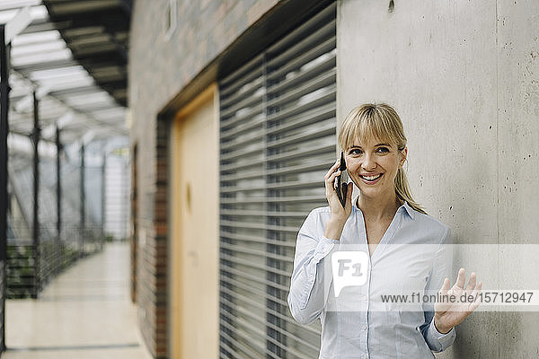 Porträt einer lächelnden jungen Geschäftsfrau am Telefon