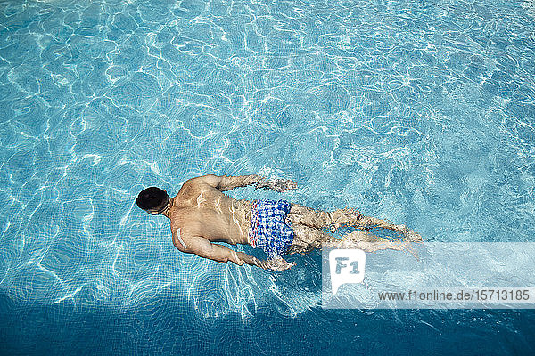 Rückenansicht eines im Schwimmbad schwimmenden Mannes
