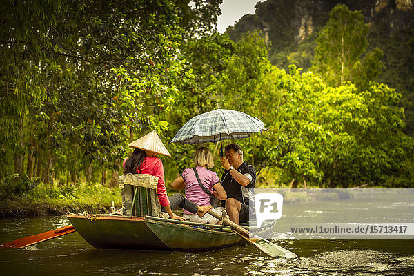 Tourists in rowing boat Ngo Dong River Ninh Binh Provice Vietnam Asia