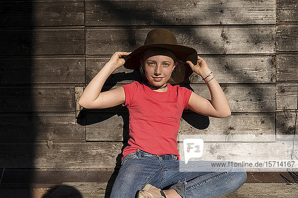 Porträt eines Mädchens mit Hut  das in der Sonne sitzt