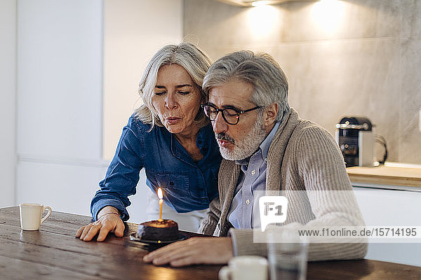 Älteres Paar feiert Geburtstag mit Kuchen in der heimischen Küche