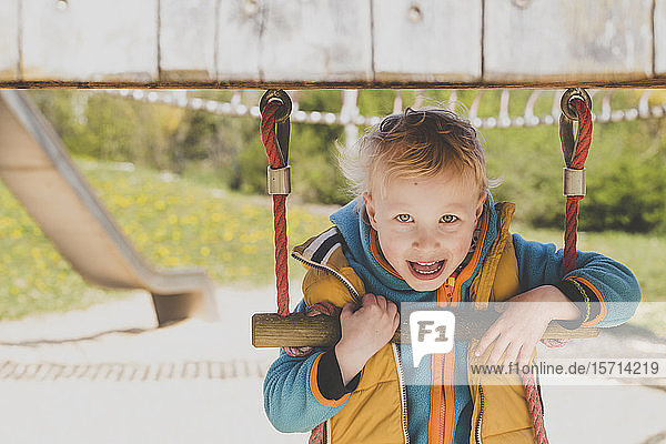 Porträt eines blonden kleinen Jungen auf einem Spielplatz