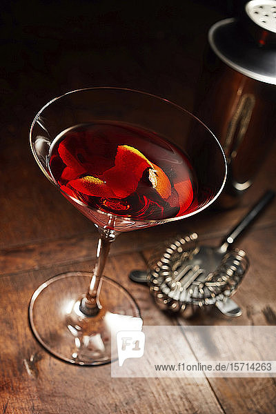Martini oder Manhattan-Getränk mit Bar-Utensilien auf Holztheke