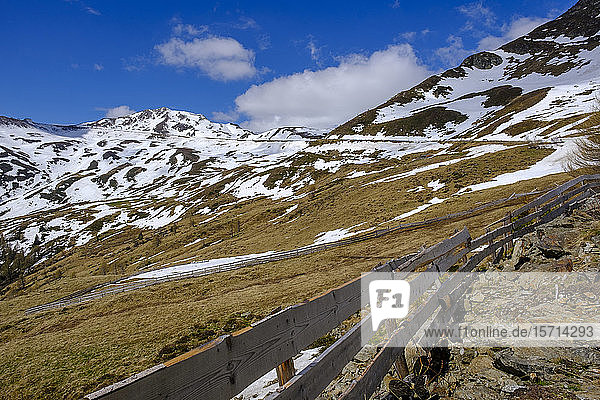 Italy  South Tyrol  Simple wooden fence in Penser Joch mountain pass with snow melting in background