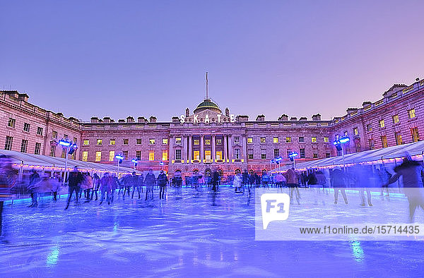 UK  England  London  People ice-skating in blue ice rink in front of Somerset House