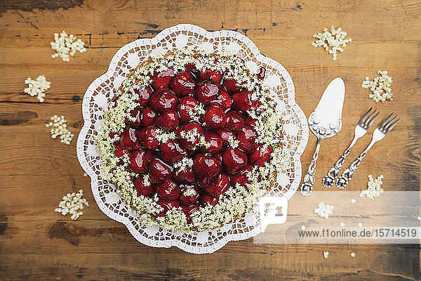 Cake stand with homemade strawberry cake decorated with elderflowers