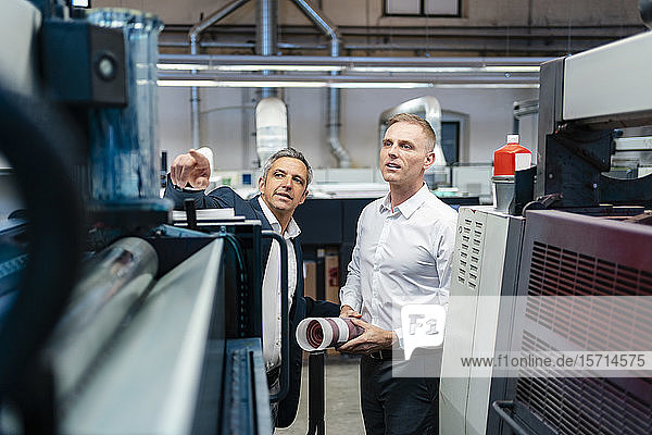 Two businessmen talking in a factory
