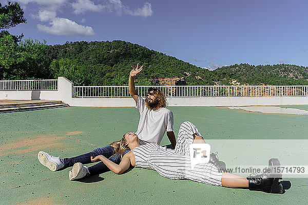 Junges Paar entspannt sich gemeinsam bei Sonnenlicht auf einer Terrasse