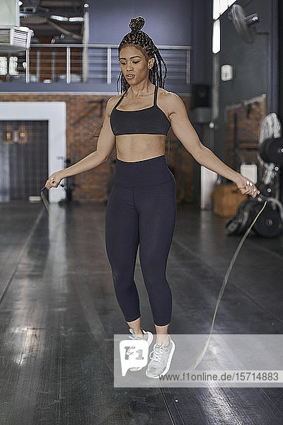 Female athlete skipping rope in gym