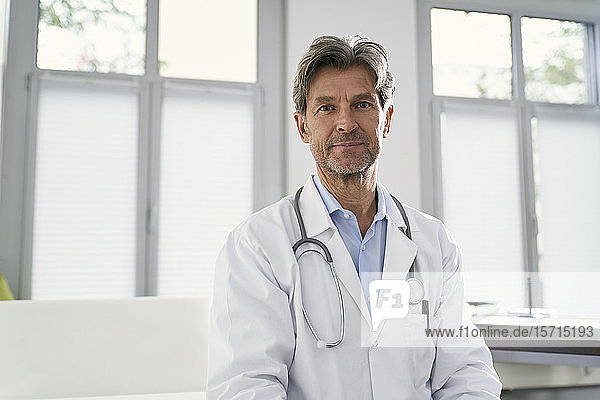 Porträt eines selbstbewussten Arztes in seiner medizinischen Praxis