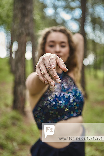 Hand einer jungen Frau im Wald  die auf den Betrachter zeigt  Nahaufnahme