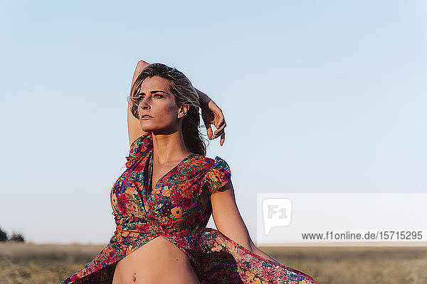 Blond woman wearing summer dress at countryside