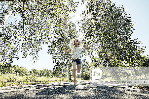 Glückliches Mädchen springt Seil auf einem Parkweg
