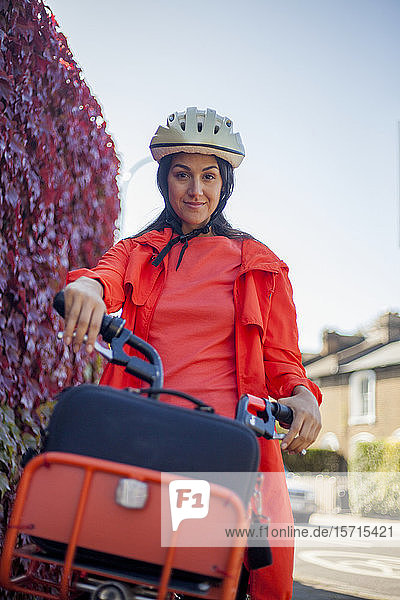 Junge Frau fährt Fahrrad und trägt einen Schutzhelm