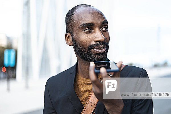 Portrait of young businessman using cell phone outdoors
