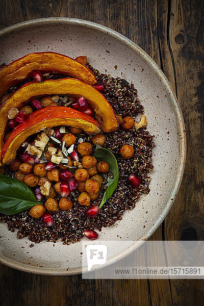 Schüssel Quinoa mit gebackenem Kürbis  Kichererbsen  Granatapfel  Basilikum  Walnüssen und Kürbiskernen