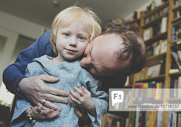 Vater umarmt seine kleine Tochter zu Hause