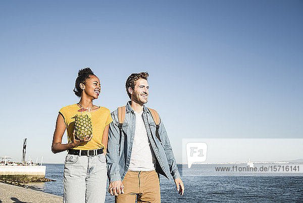 Glückliches junges Paar beim Spaziergang am Pier am Wasser  Lissabon  Portugal