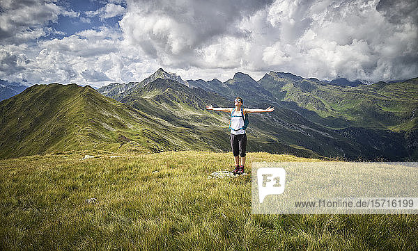 Fröhliche Frau  die eine Pause vom Wandern im Stehen auf der Alm macht  Passeiertal  Südtirol  Italien