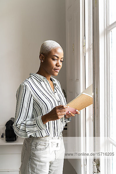 Woman reading notebook at the window