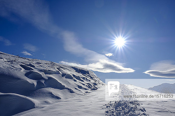 Germany  Bavaria  Wendelstein  Sun shining over footprints in heavy snow