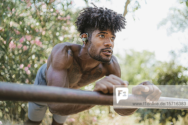 Young man during workout on bar in park
