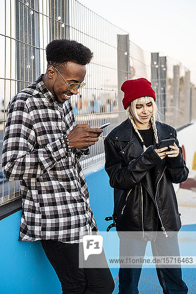 Junges Paar benutzt Smartphones im Freien