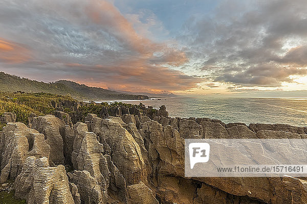 Neuseeland  Distrikt Buller  Punakaiki  Kalkstein-Pfannkuchenfelsen-Formation und Küsten-Blasloch in der Abenddämmerung
