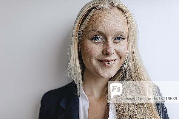 Porträt einer lächelnden blonden jungen Geschäftsfrau